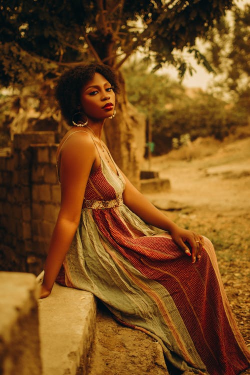 Woman in Dress Sitting on Wall