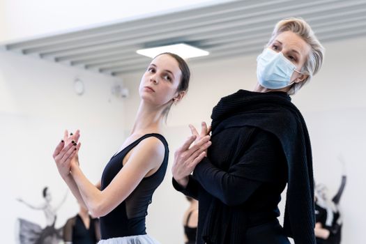 Two women engaged in ballet training, showcasing grace and focus indoors.