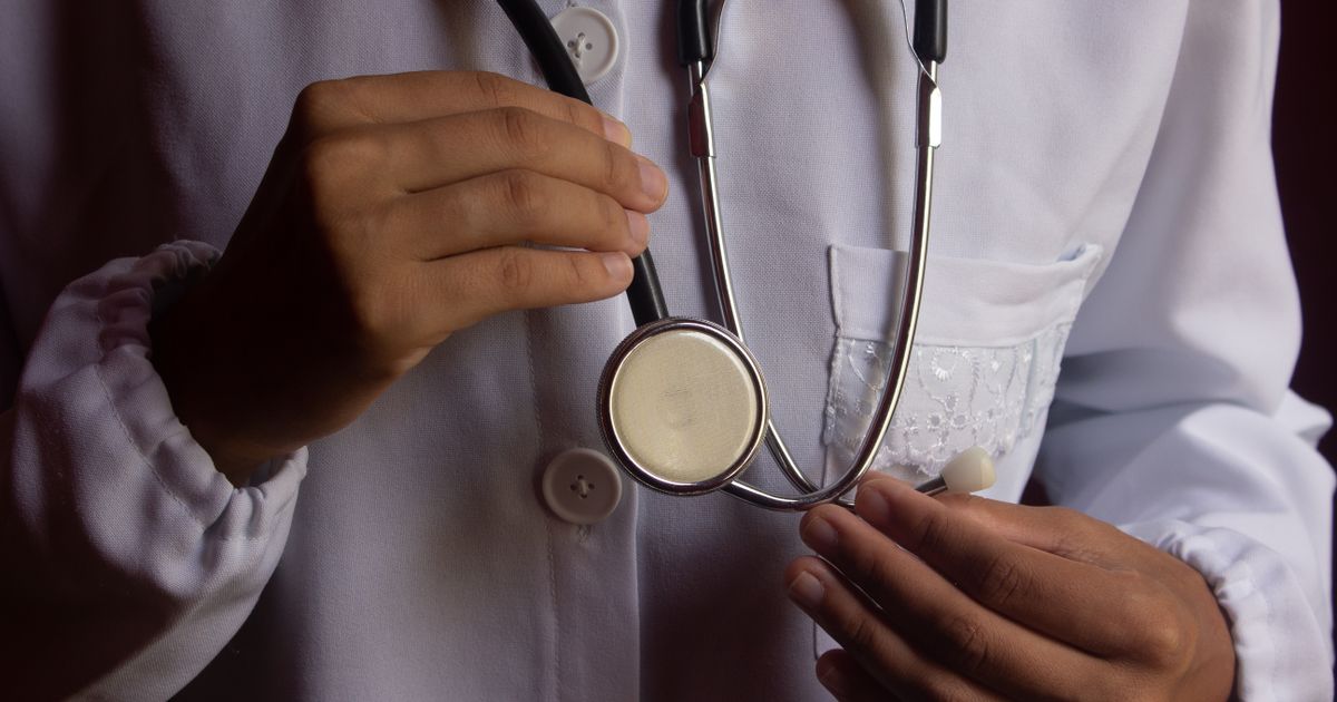 Close-up of a doctor’s hands holding a stethoscope.