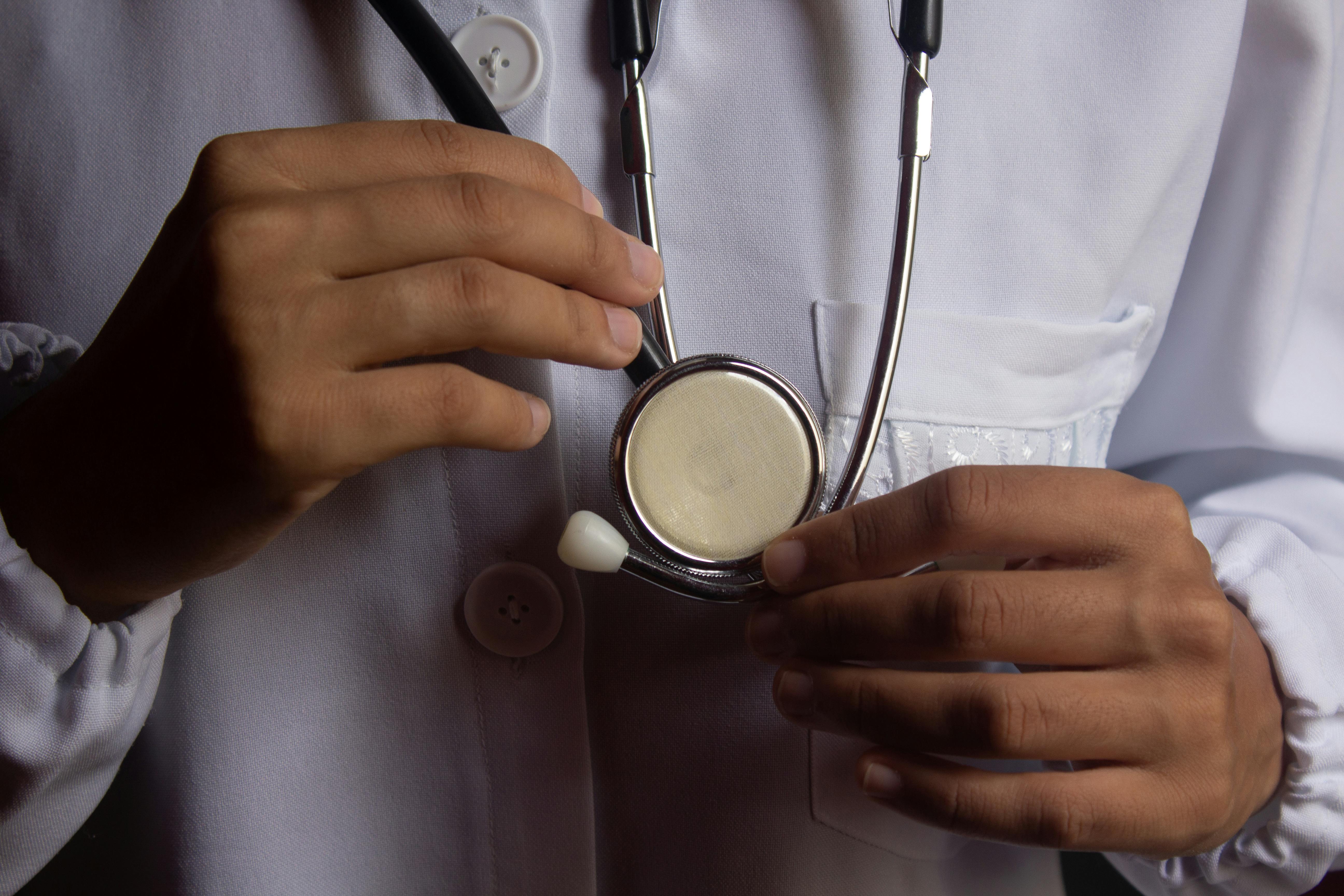 A close-up of a stethoscope in the hands of a family doctor ready to examine a patient