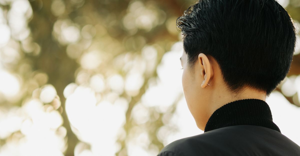 person wearing a small neural patch behind ear