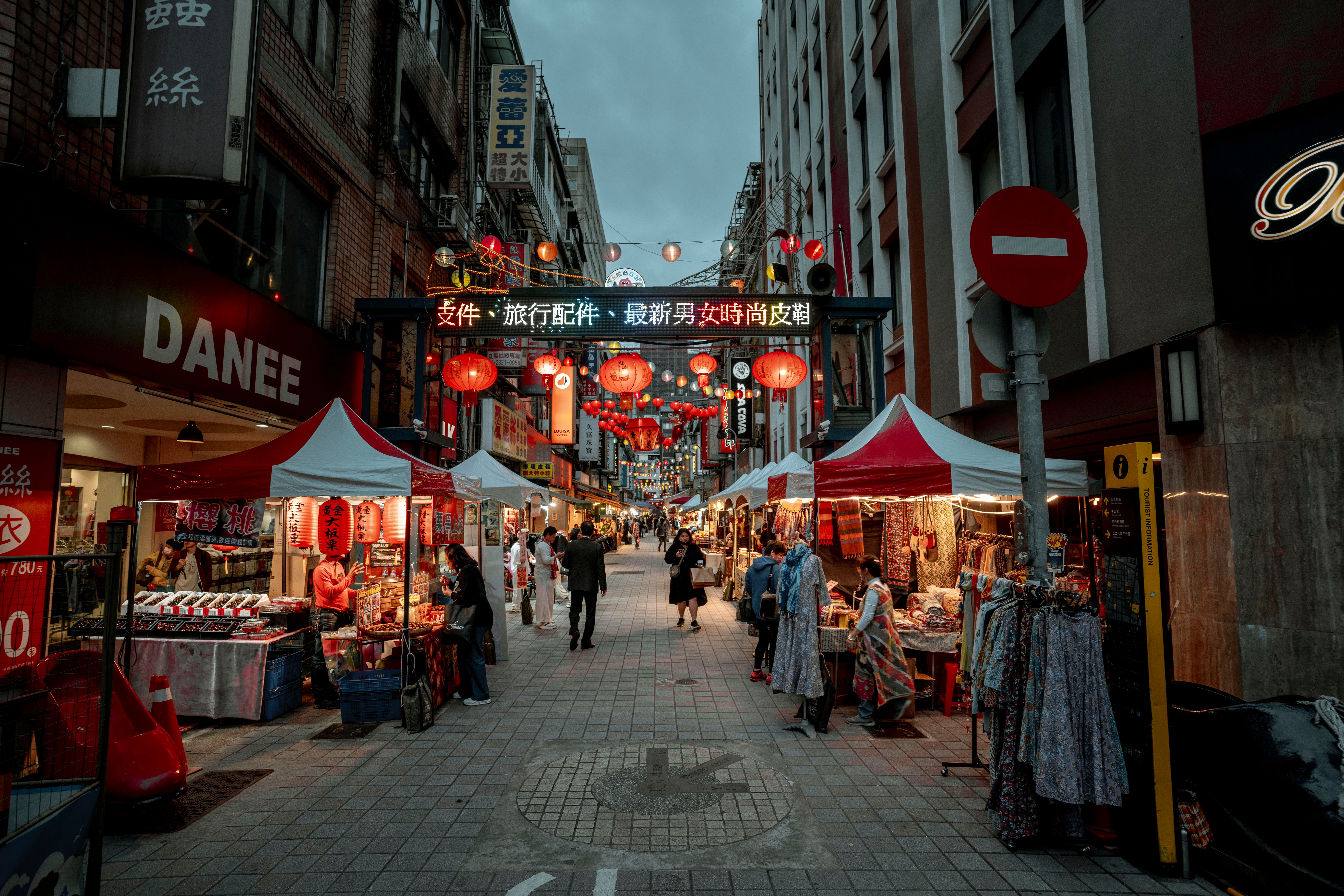 Singapore Chinatown Street Market at night with red lanterns glowing above rows of food stalls and souvenir shops