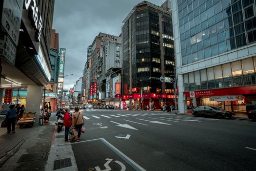View of a busy city street with high-rise buildings and pedestrians in an urban setting.
