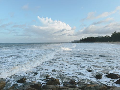 Breakwater with crashing waves and a beautiful view of the beach in the monsoon season.