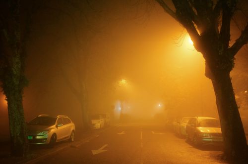 Free A moody and atmospheric street in Porto, Portugal, laden with fog under streetlights. Stock Photo