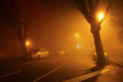 Free Misty urban night scene in Porto with fog illuminated by streetlights and parked cars. Stock Photo