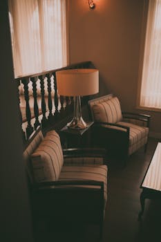 Elegant living room corner featuring classic armchairs and a lamp, exuding warmth and style.