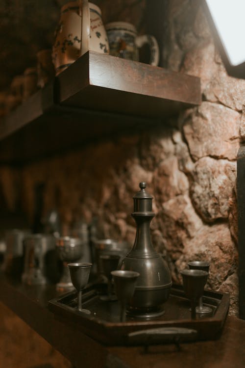 Close-up of Antique Pottery and Kitchenware on Wooden Shelves 