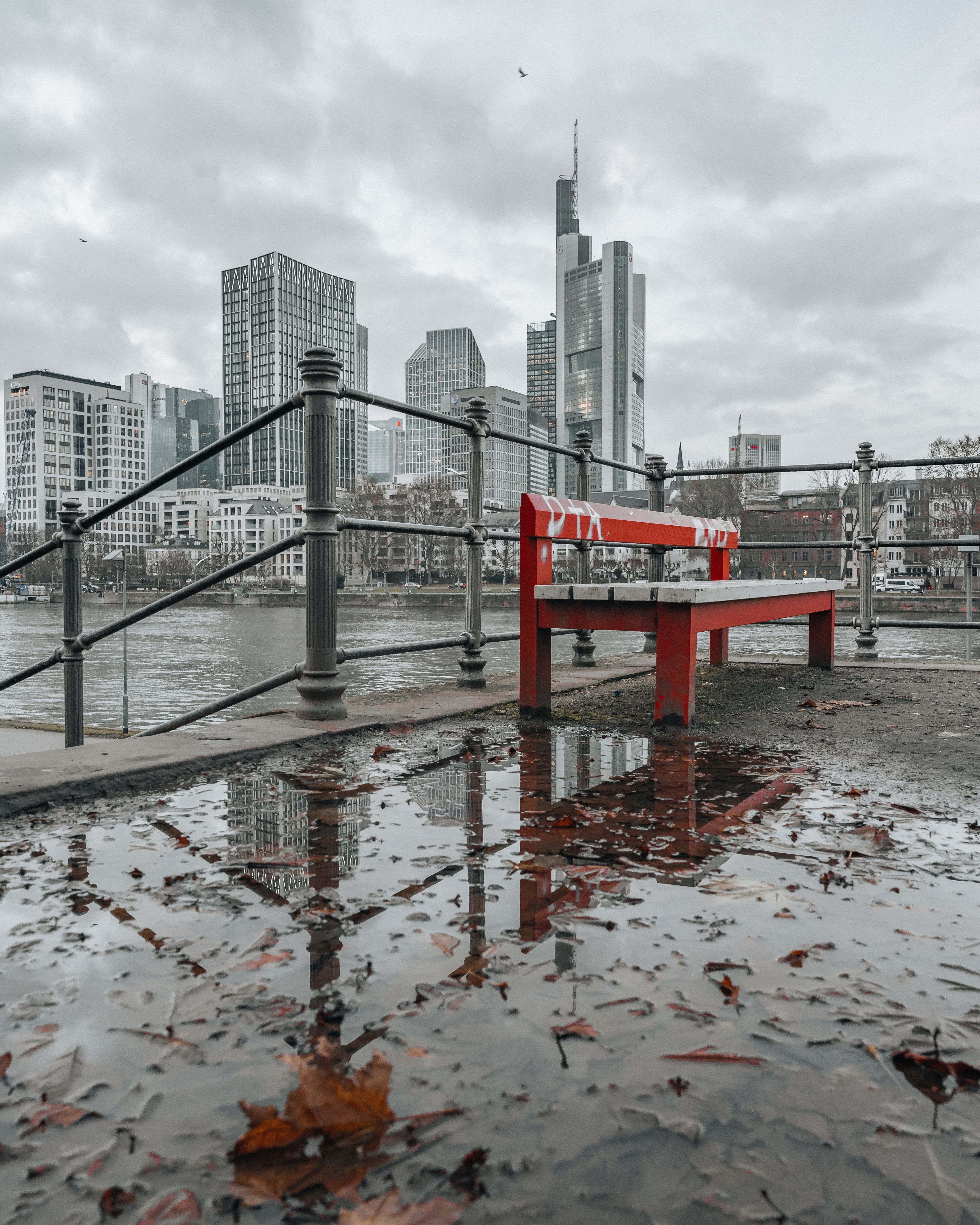 City Skyscrapers behind Bench by River · Free Stock Photo