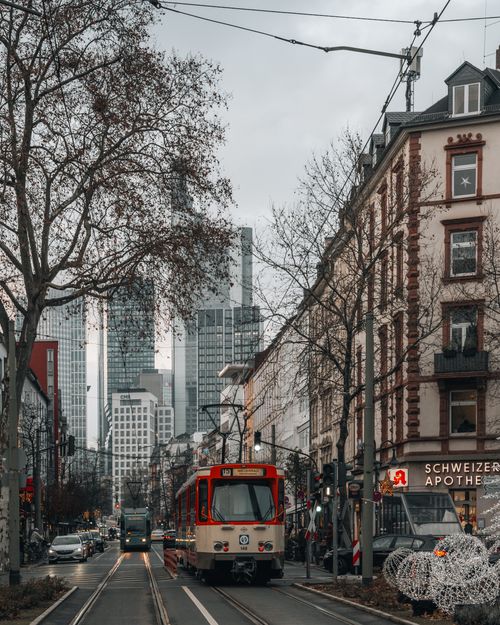 Free Street view of a city tram among urban architecture and skyscrapers. Stock Photo