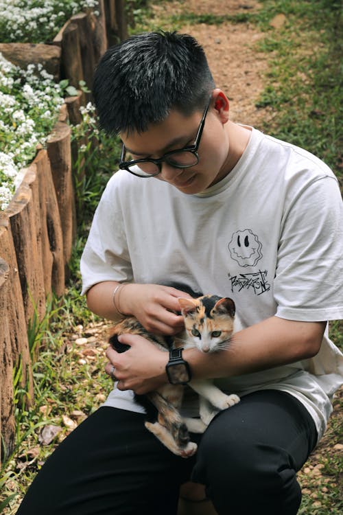 Man Squatting with Kitten