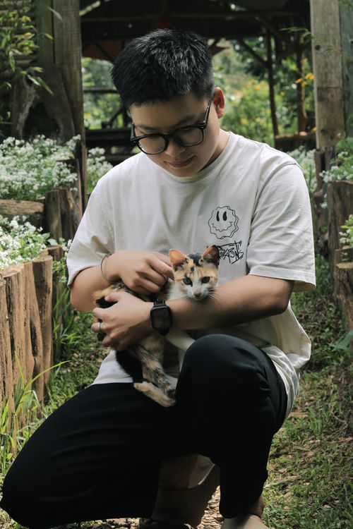 Free Young man in garden, embracing cat, creating a peaceful connection. Stock Photo