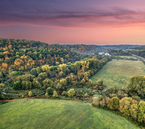 Aerial View of Fields and Trees under a Dramatic Sunset Sky 