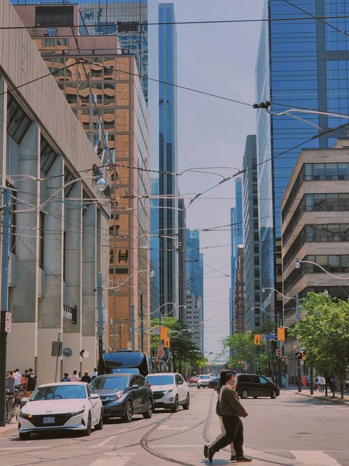 Free Street view of bustling downtown Toronto with pedestrians, cars, and skyscrapers on a sunny day. Stock Photo