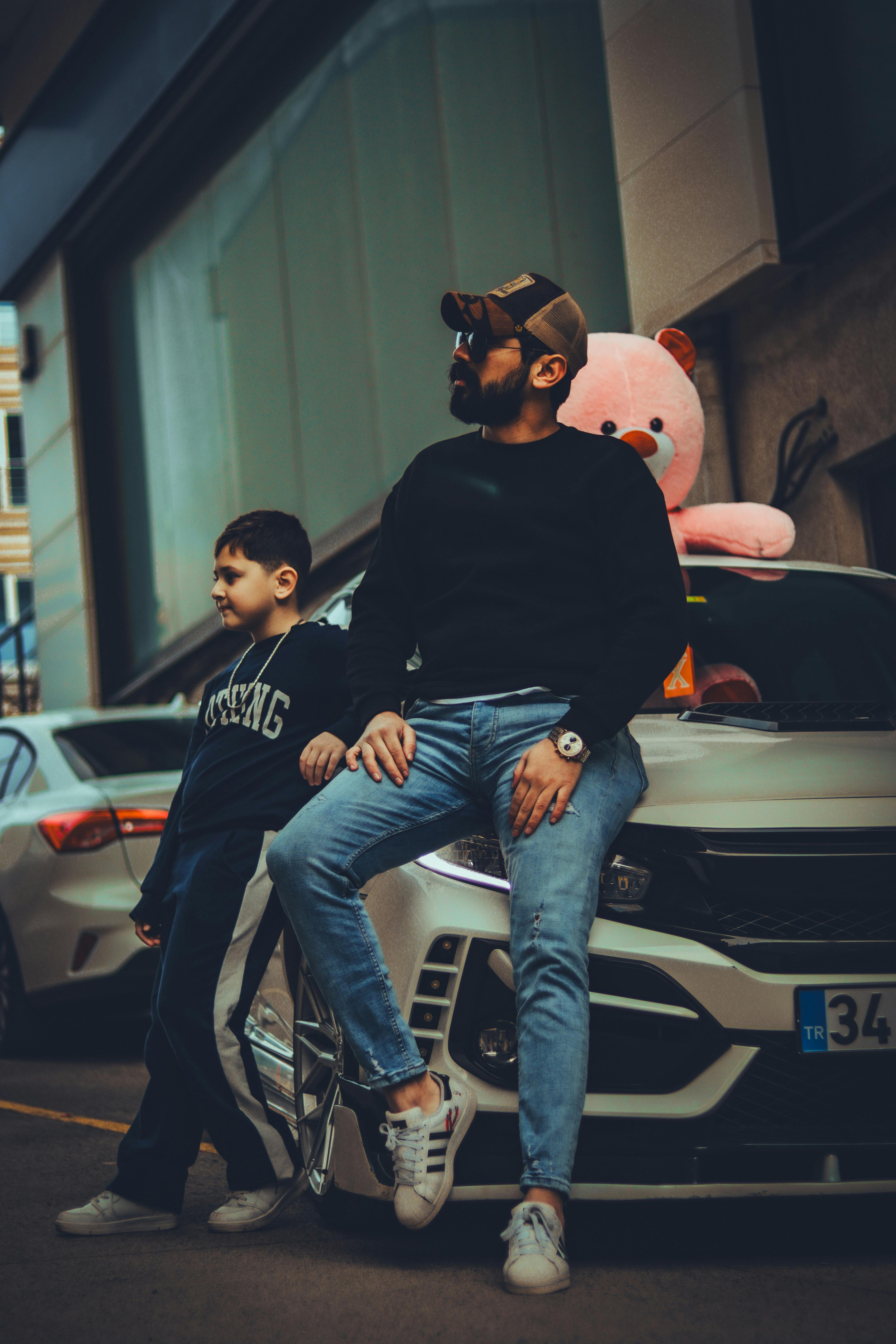 father and son by a honda civic type r with a big pink teddy bear looking through the sunroof