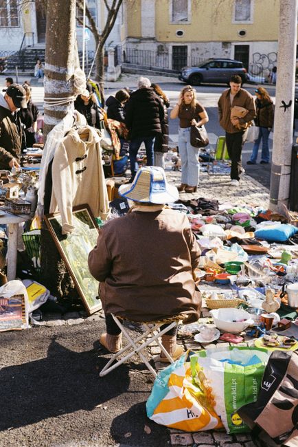 Discover the lively street market in Lisbon with people shopping and browsing vibrant stalls. — Feira, Portugal.
