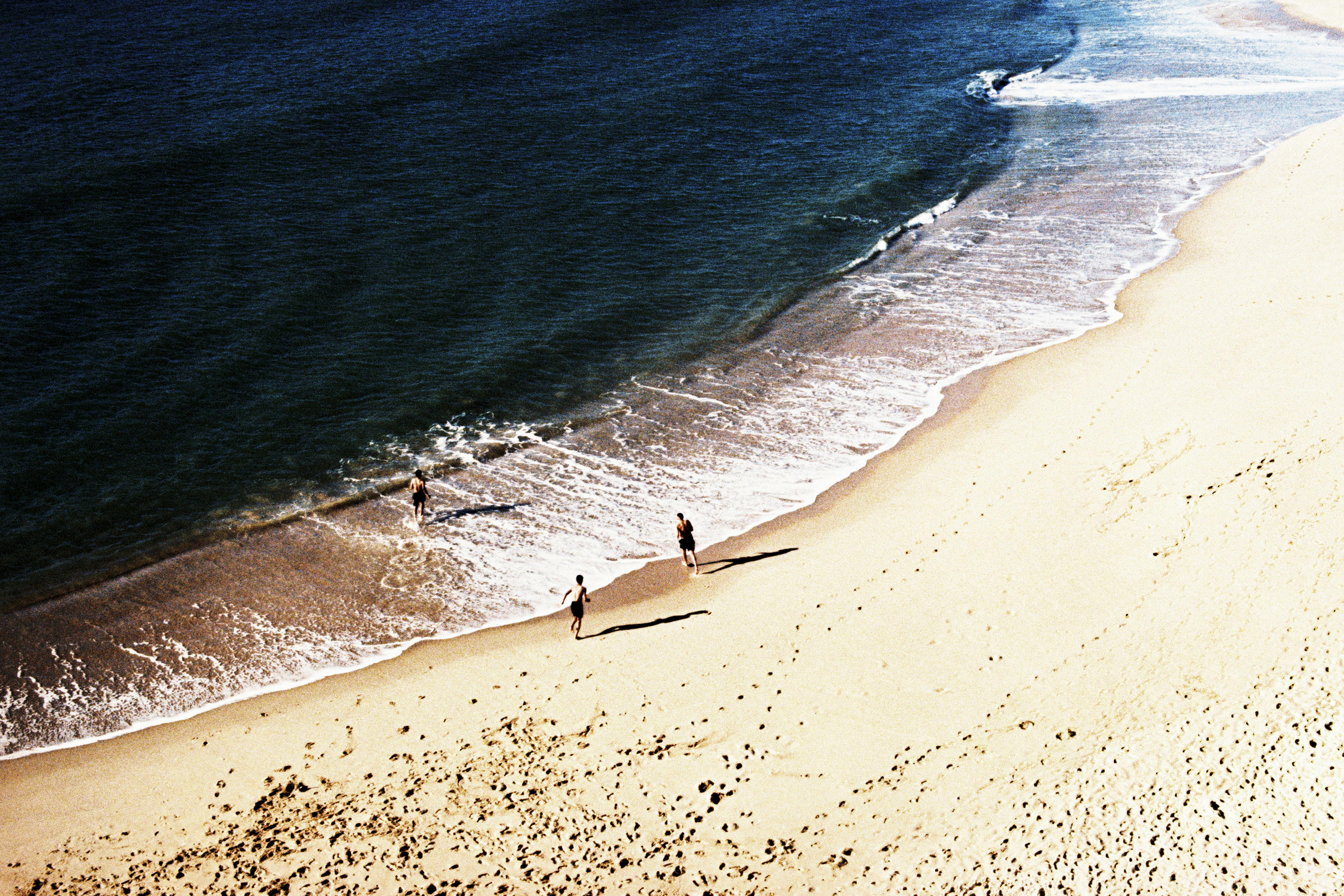 Stunning aerial view of Nazaré beach in Portugal with people enjoying the summer coastline.