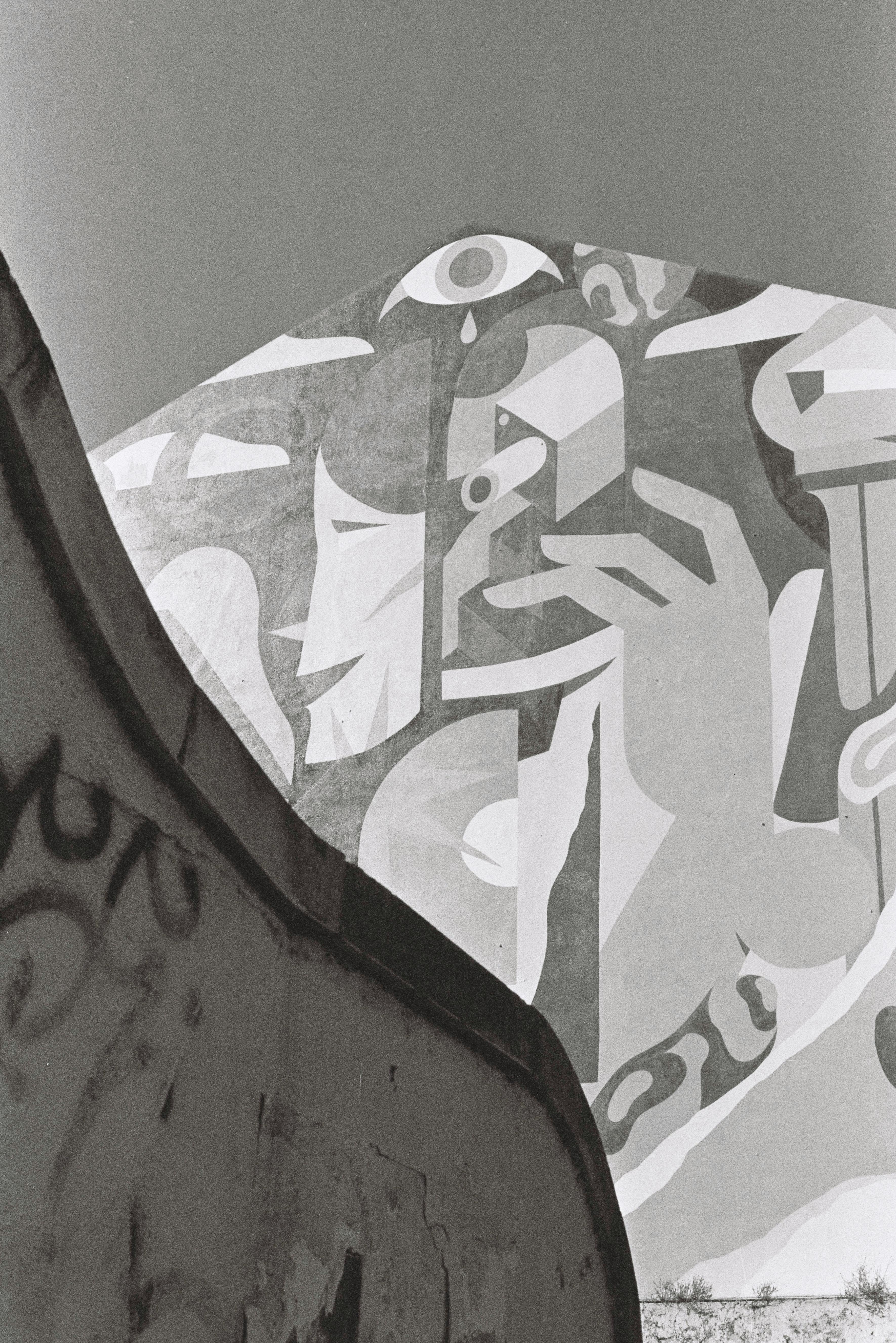 Urban graffiti mural in Lisbon, showcasing modern art against a clear sky.