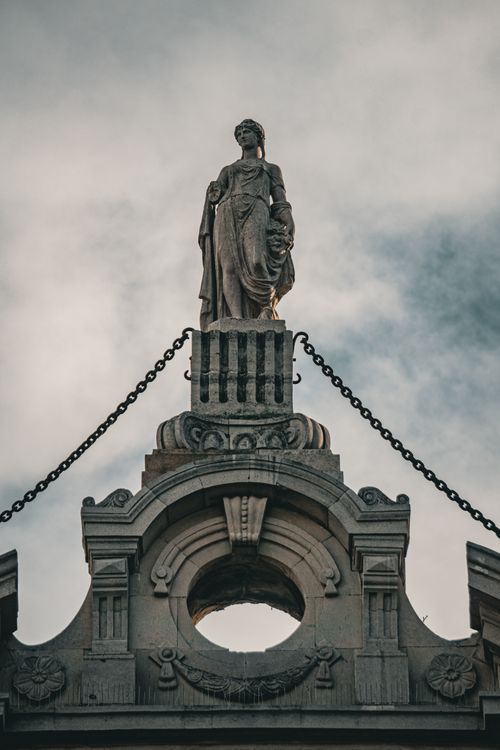 Free Majestic stone statue graces the rooftop of a historic building in Baku, Azerbaijan. Perfect for architectural themes. Stock Photo