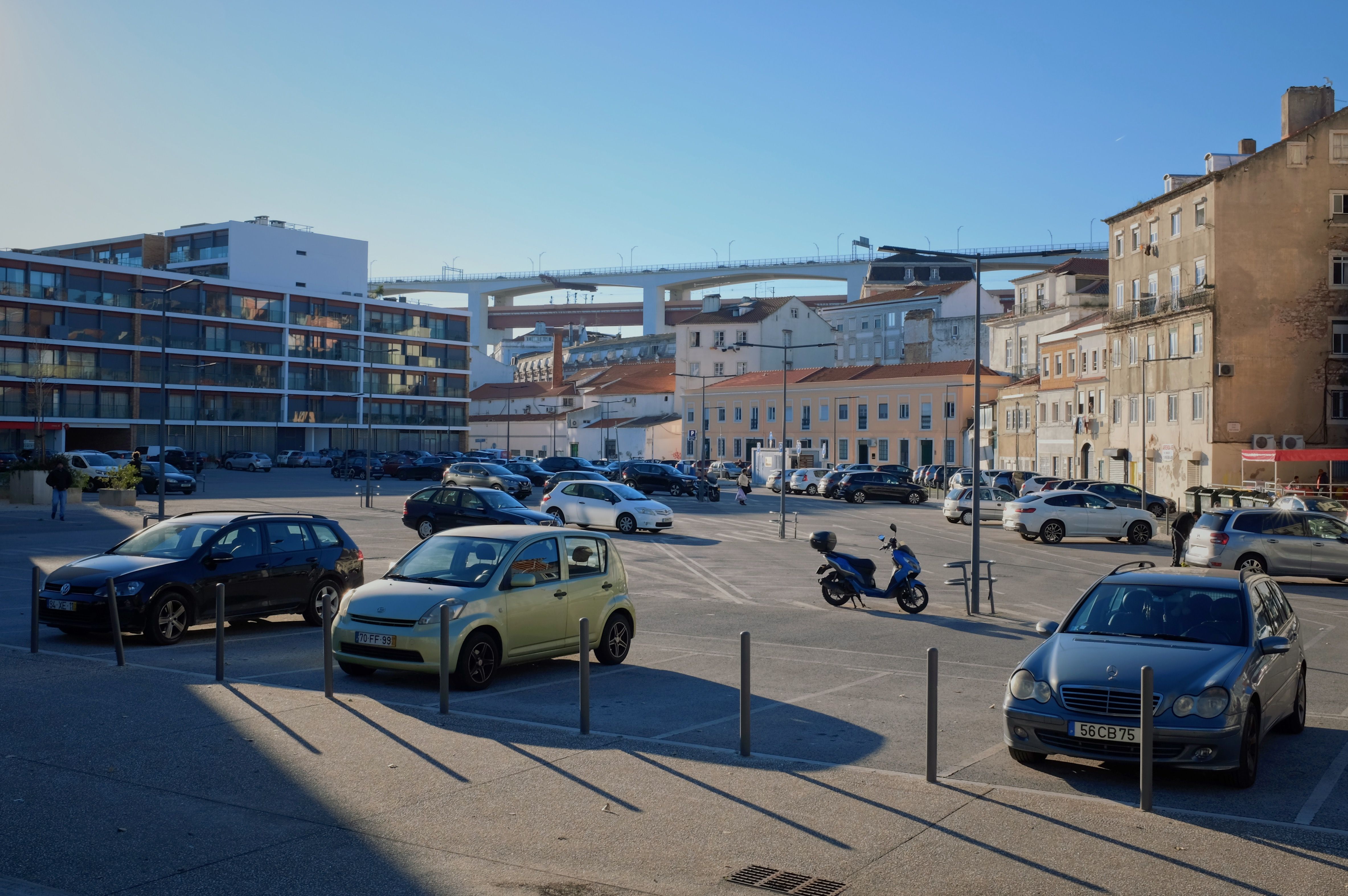 Narrow Lisbon street with cars parked along a steep cobbled hill