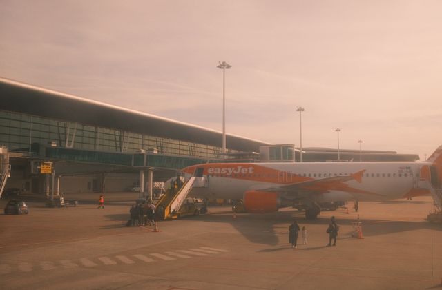 An EasyJet aircraft parked at Porto airport under warm daylight, ready for boarding. — arriving in Porto