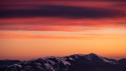 Free Breathtaking sunset with vibrant colors over snow-covered mountain peaks, creating a dramatic landscape view. Stock Photo