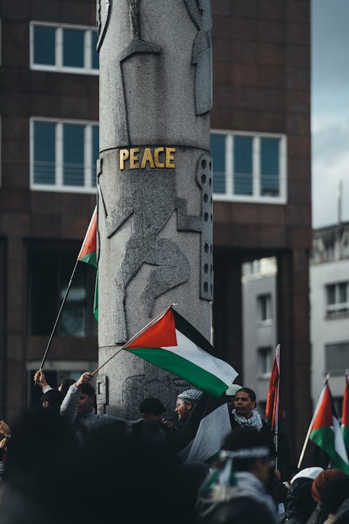 A group of people holding flags and a pole