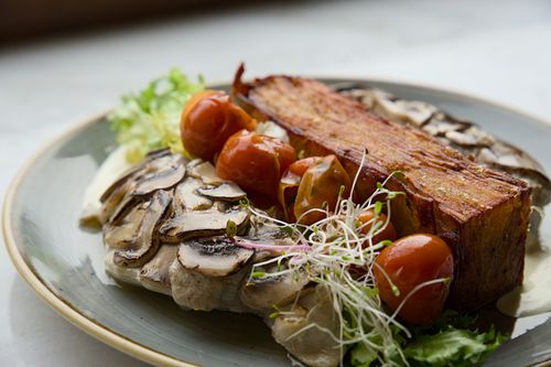Free Delicious gourmet dish featuring mushrooms, cherry tomatoes, and puff pastry, perfect for food enthusiasts. Stock Photo