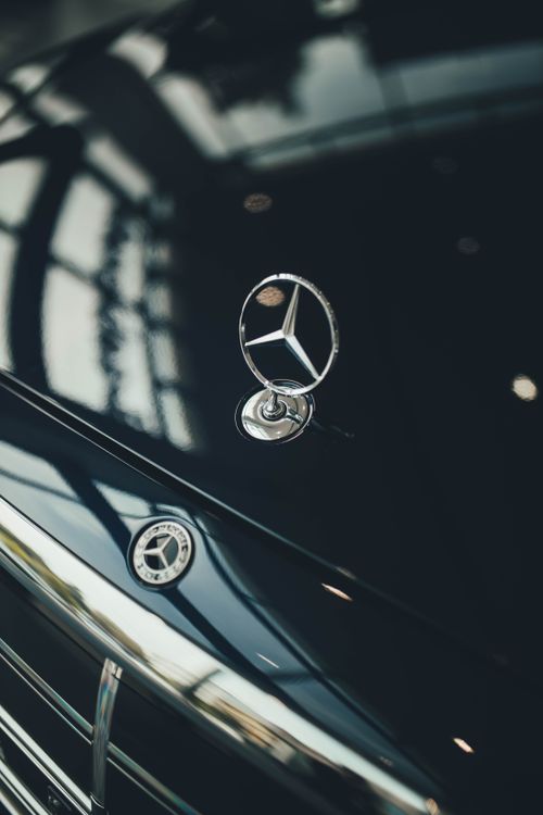 Free A detailed view of a luxury car hood emblem captured outdoors, showcasing elegance and design. Stock Photo