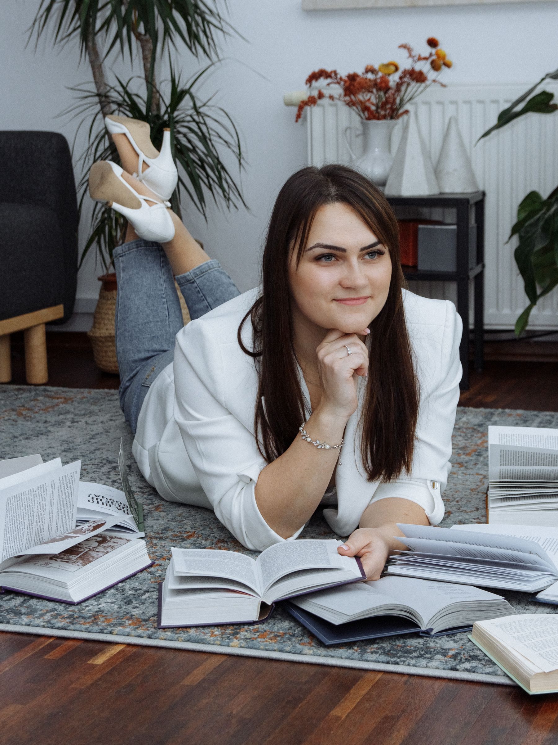 Smiling Woman Lying Down with Books on Floor · Free Stock Photo