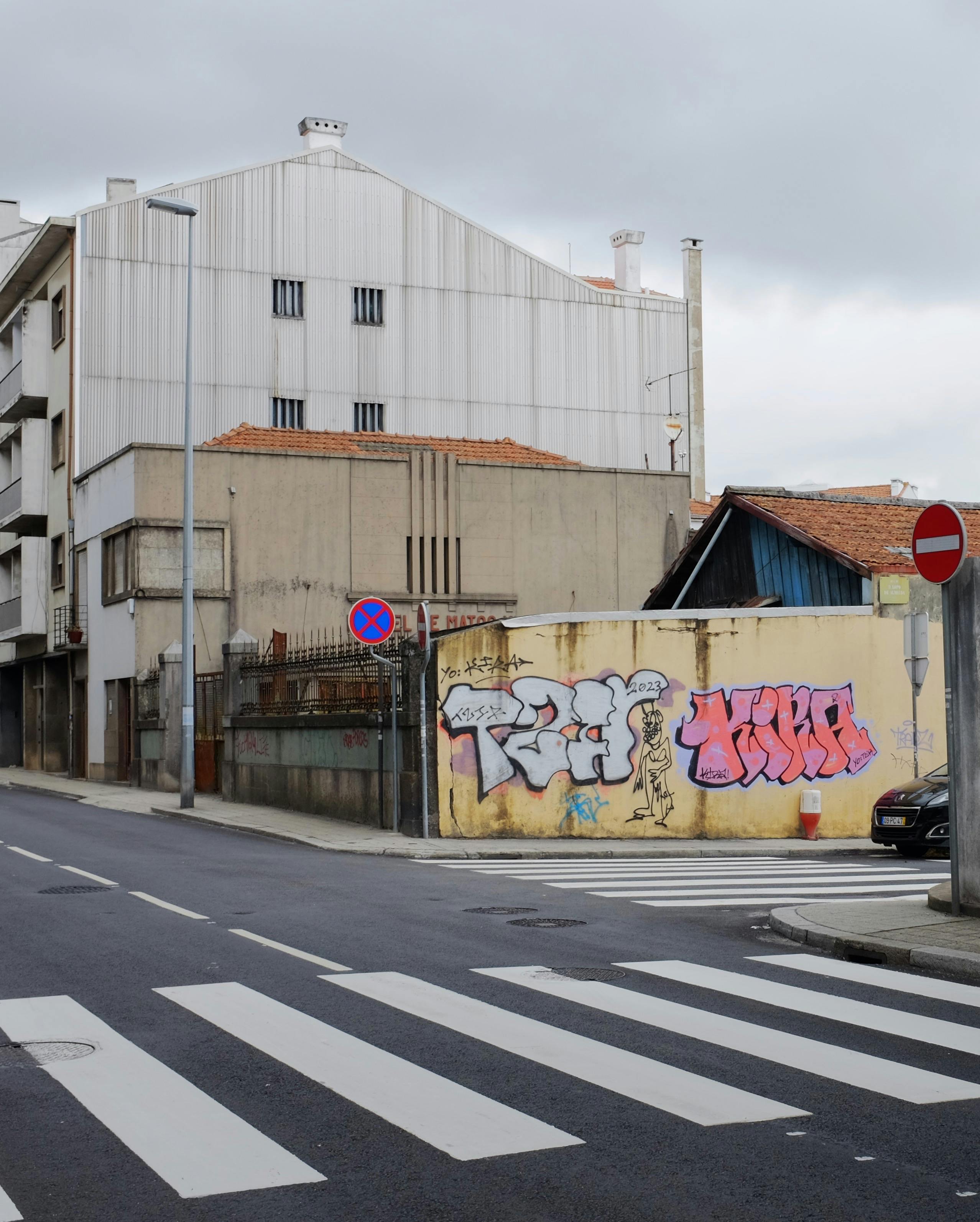 Graffiti-covered street and buildings in Porto, Portugal's vibrant urban landscape.
