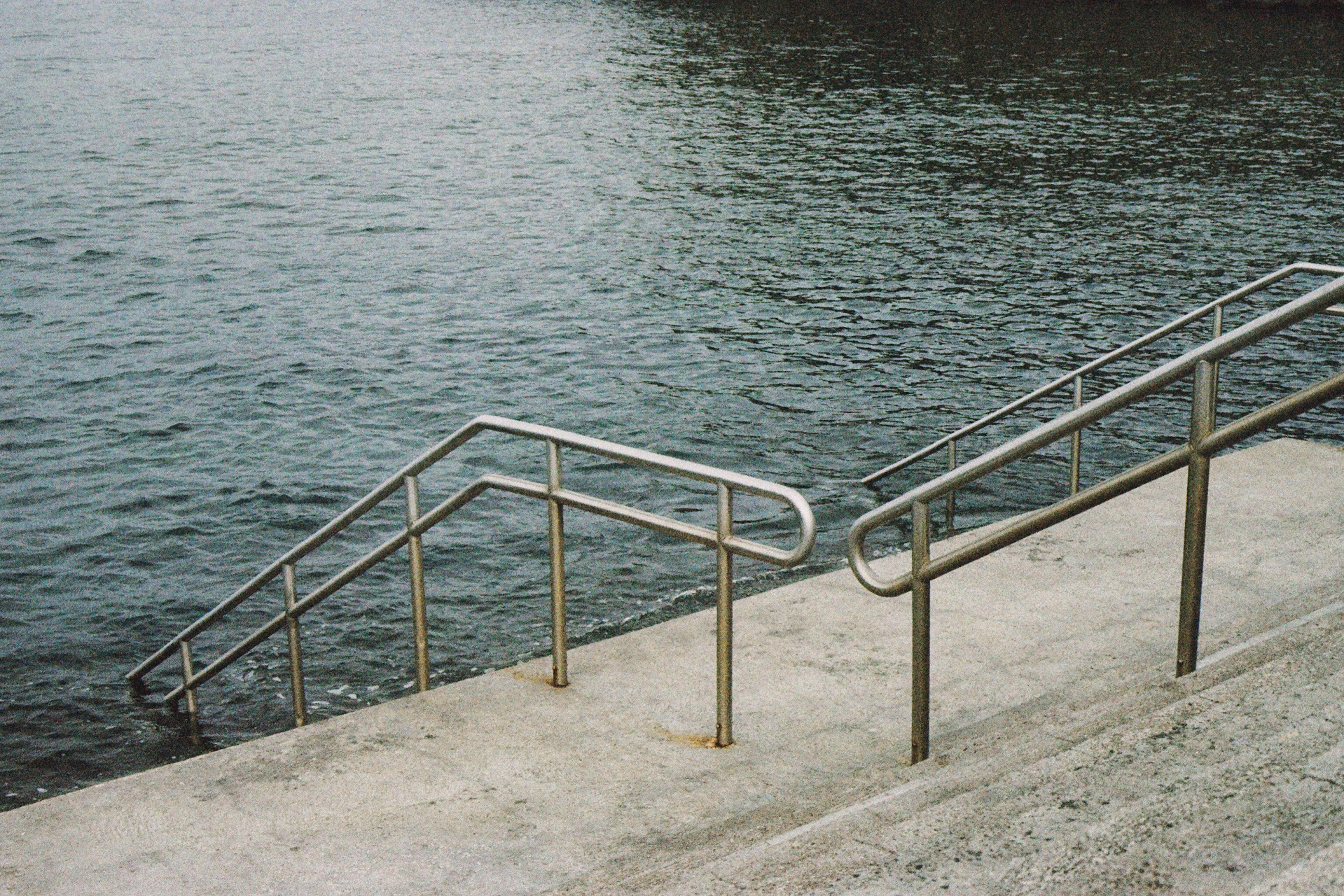 Metal stairs and handrails descend into the water in the scenic Azores, Portugal.