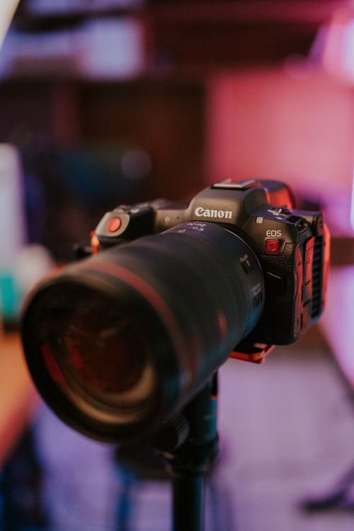 Free Close-up image of a Canon camera mounted on a tripod, featuring a blurred background. Stock Photo