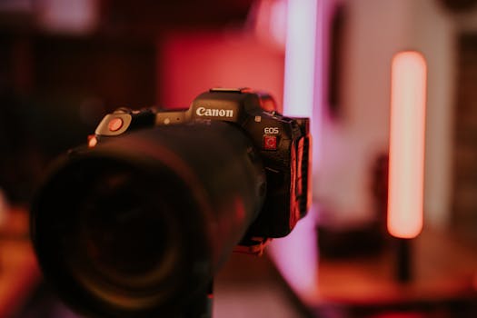 Artistic close-up of a DSLR camera with colorful lighting in an indoor setting.
