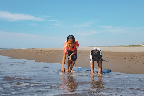 Free Two children playing in the water on the beach Stock Photo