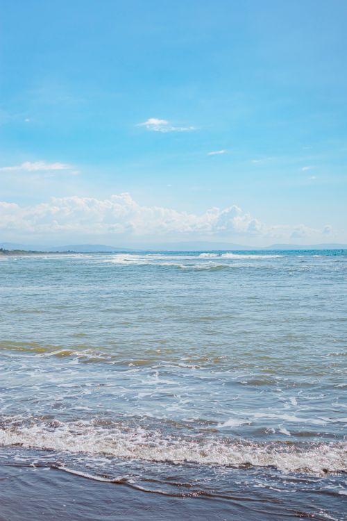 Free Peaceful ocean view under a bright sky, capturing the serene beauty of the sea and shore. Stock Photo