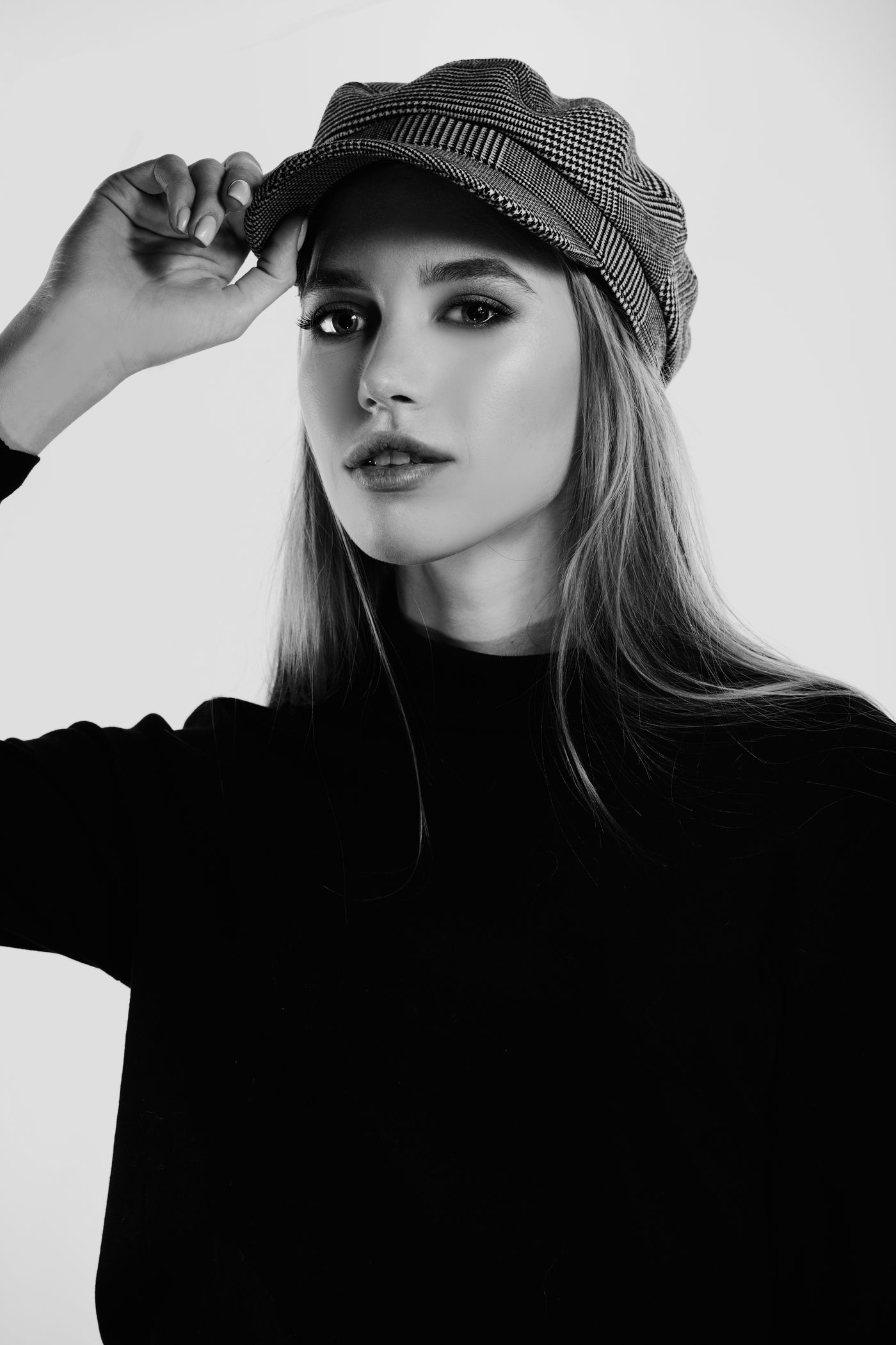 Look de noche en negro de Atelier Norte: jersey de cuello alto negro y gorra
