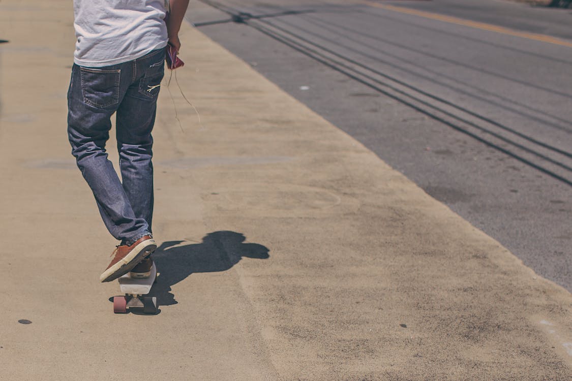 Man Riding Skateboard on Road