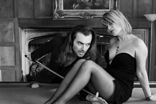 Free A couple in a romantic black and white setting on a pool table indoors. Stock Photo