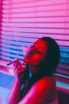 Cinematic portrait of a young woman smoking indoors, illuminated by vibrant neon lights.