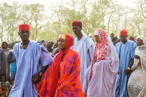 Free Vibrant traditional celebration with couples in colorful attire holding hands outdoors. Stock Photo