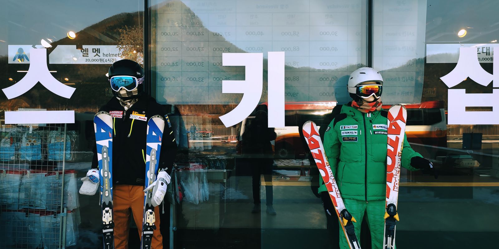 Skiers in winter gear holding skis in front of a ski shop