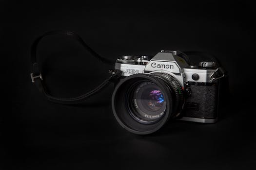 Elegant close-up of a vintage Canon AE-1 camera on black background.