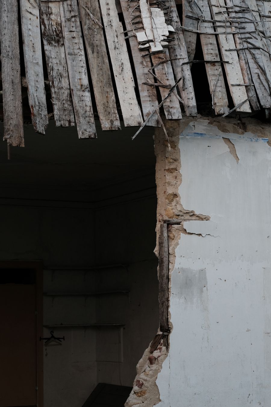 Close view of damaged roof framing and exterior wall after property damage