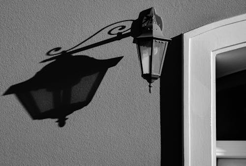 Black and White Photo of a Lamp on a Wall 
