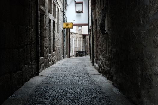 Captivating narrow alley with stone walls in Guimarães, Portugal, evoking a sense of history.