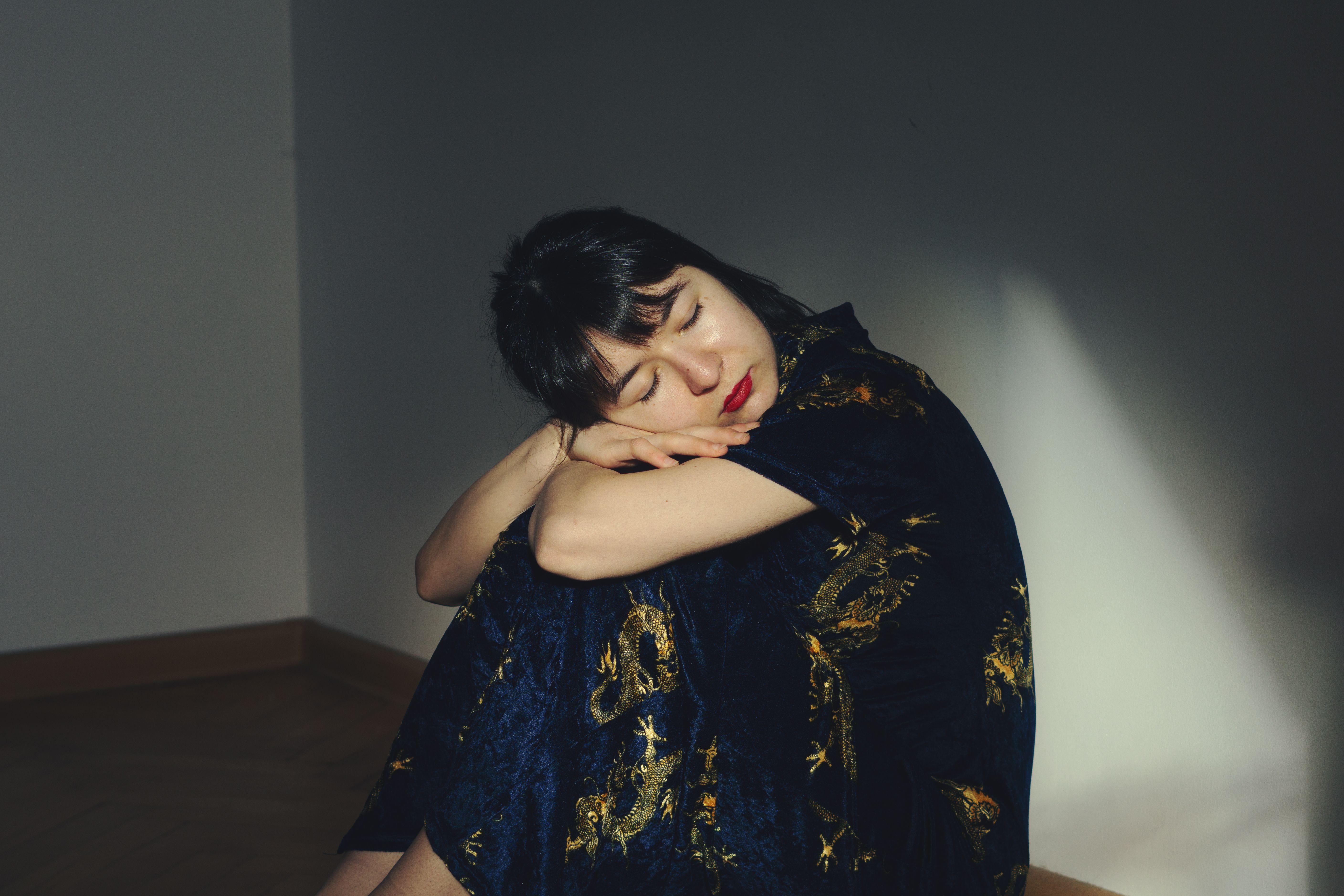 A woman in a blue dress is sitting on the floor · Free Stock Photo