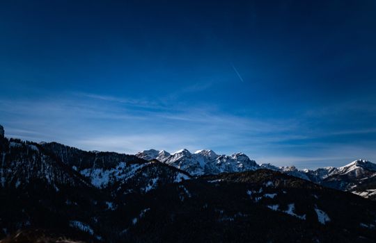A breathtaking view of a snow-capped mountain range under a clear blue sky, ideal for winter landscape photography.