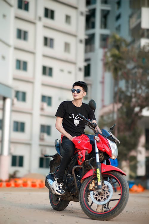 Man in T-shirt and Sunglasses Sitting on Motorbike
