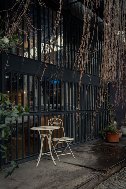 Table and Chair near Bars on Wall